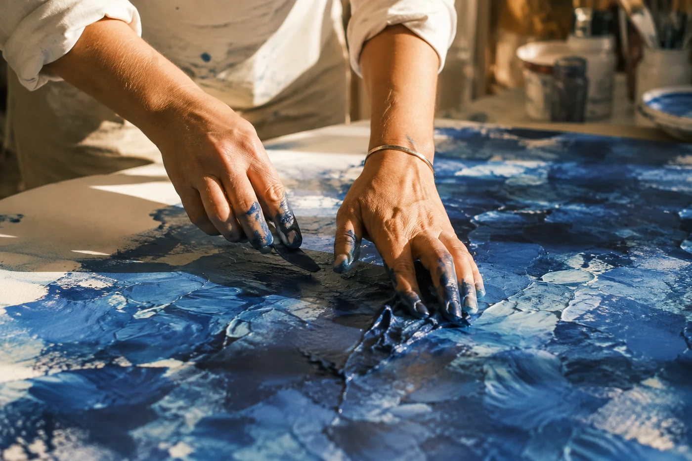 An artist working cobalt pigment into a canvas.